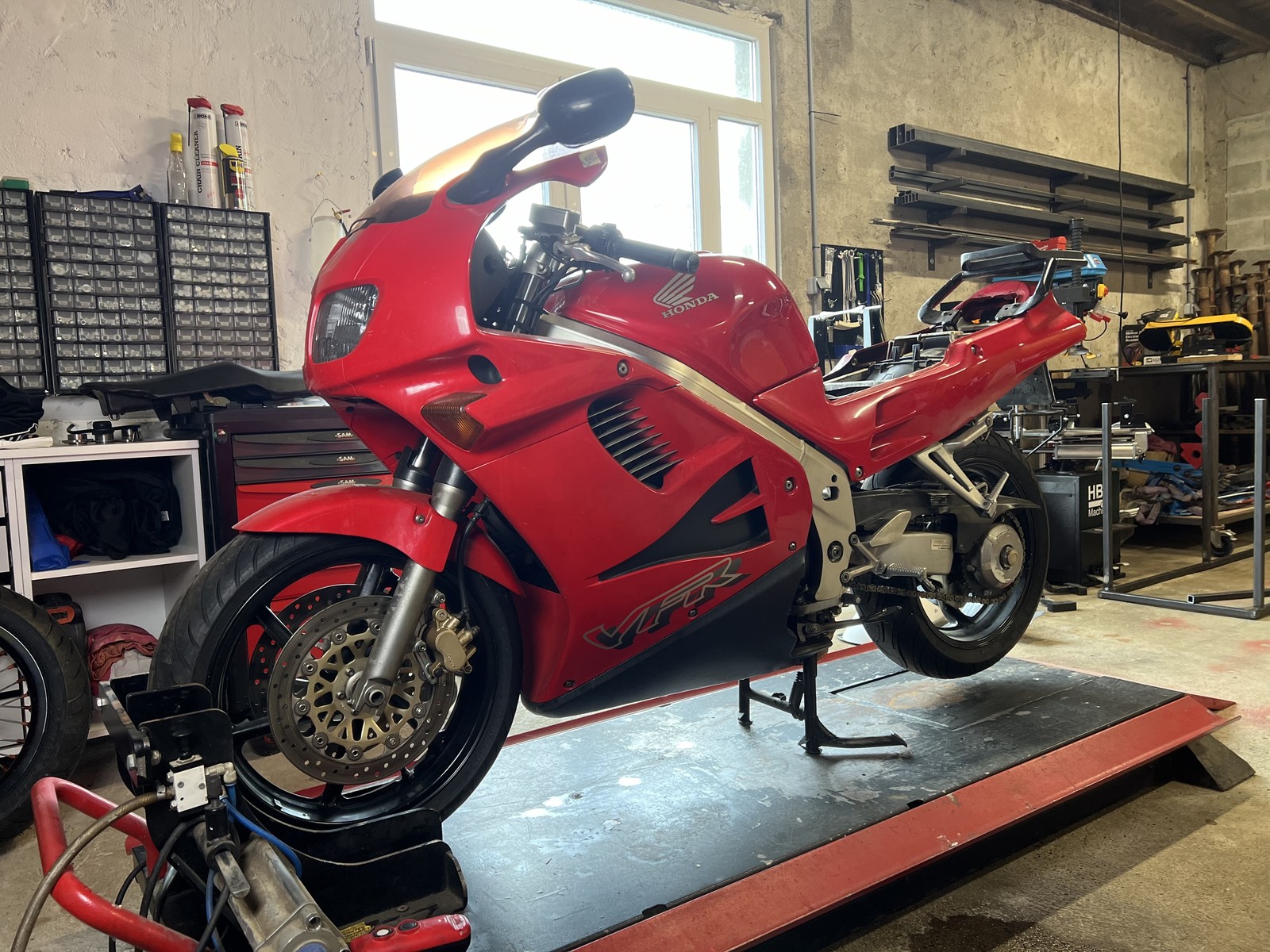 La VFR750F rouge avant sa transformation à l’atelier.